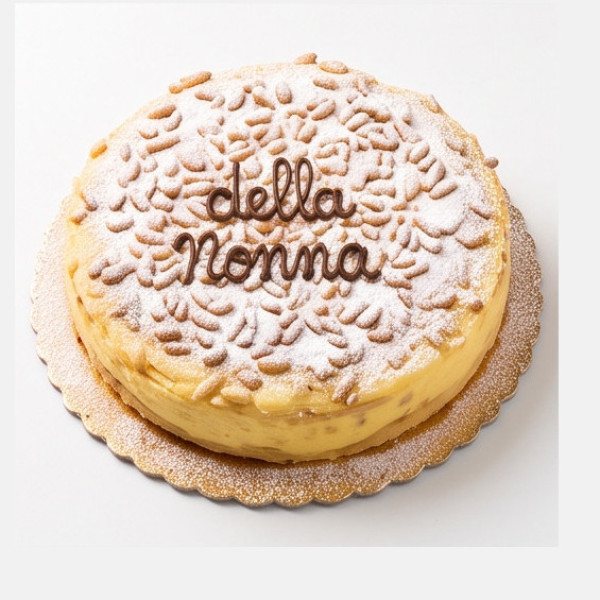 Torta rotonda con pinoli e zucchero a velo, scritta «della nonna» in cioccolato e vassoio dorato.